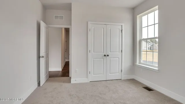 an empty room with windows and closet