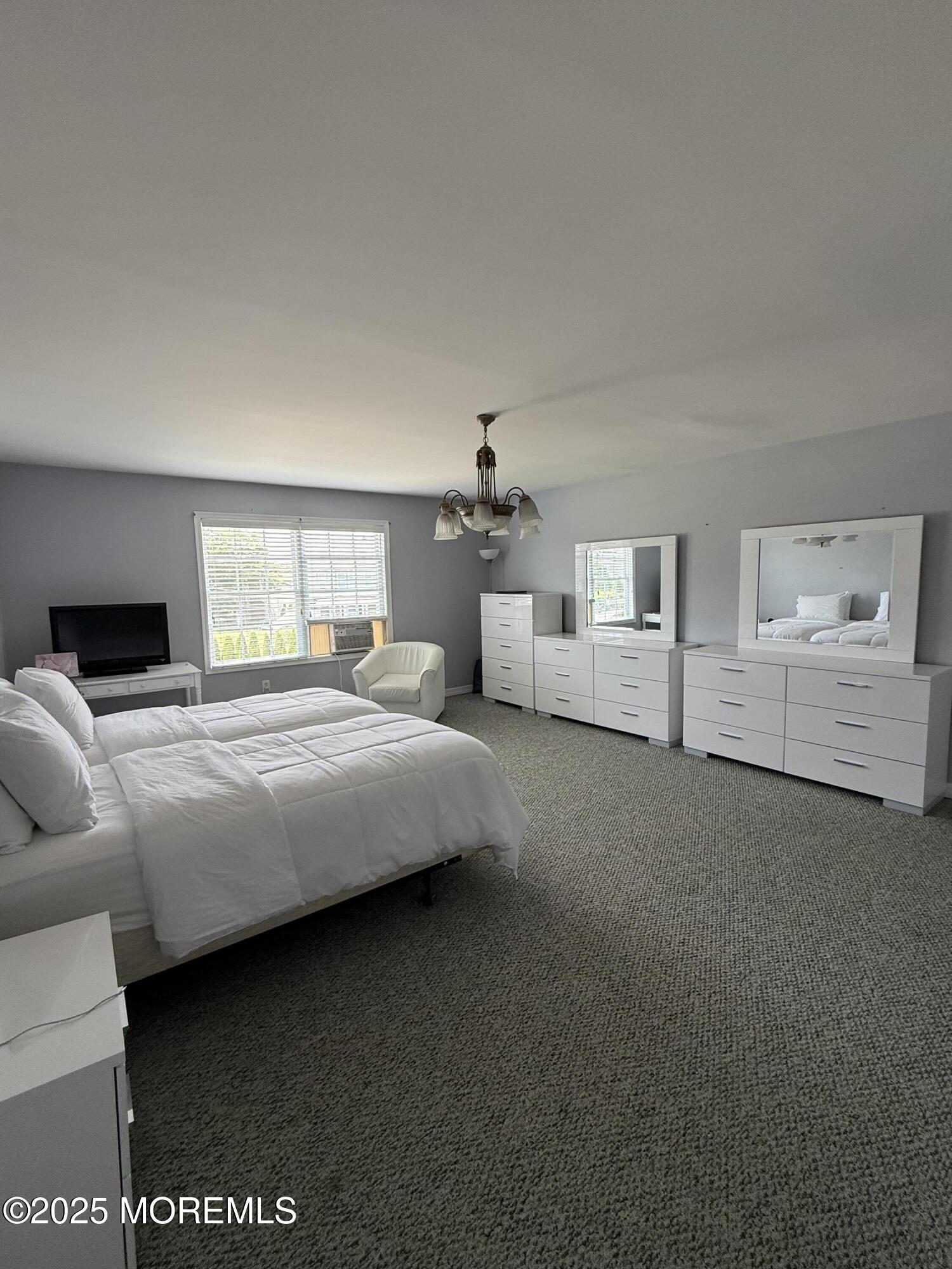 519 2nd Avenue Long Branch, NJ 07740 - Photo 13 of 24 a bedroom with a large bed and a chandelier