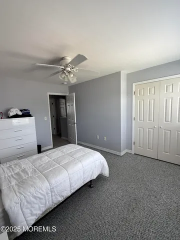 a bedroom with a large bed and a chandelier fan