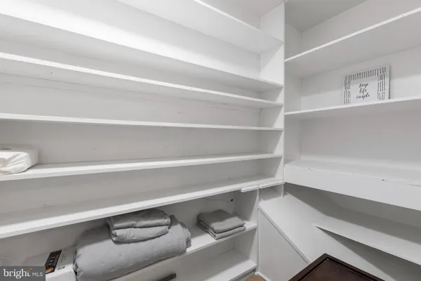 a view of walk in closet with empty racks