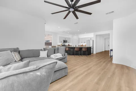 a living room with furniture and a ceiling fan
