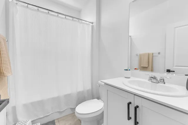 a bathroom with a sink a toilet and shower curtain