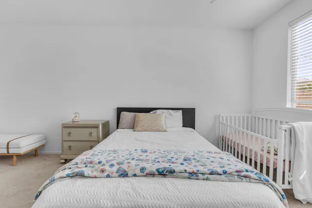a bedroom with a bed and a flat screen tv in white walls