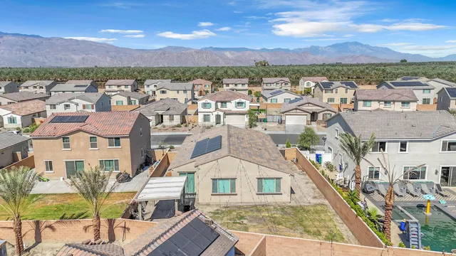 an aerial view of residential houses with outdoor space and mountain view