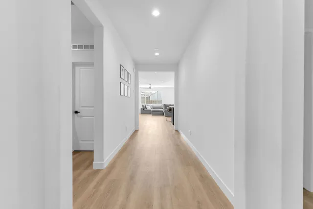 a view of a hallway with wooden floor