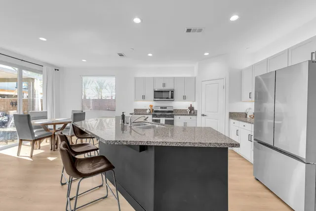 a kitchen with refrigerator and chairs