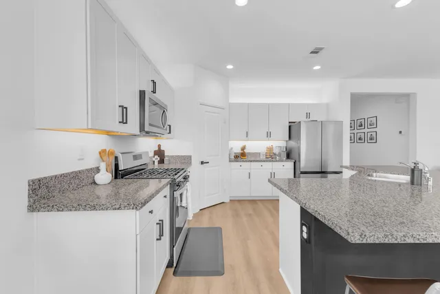 a kitchen with stainless steel appliances granite countertop a sink stove and refrigerator