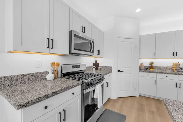 a kitchen with granite countertop a sink stove and cabinets