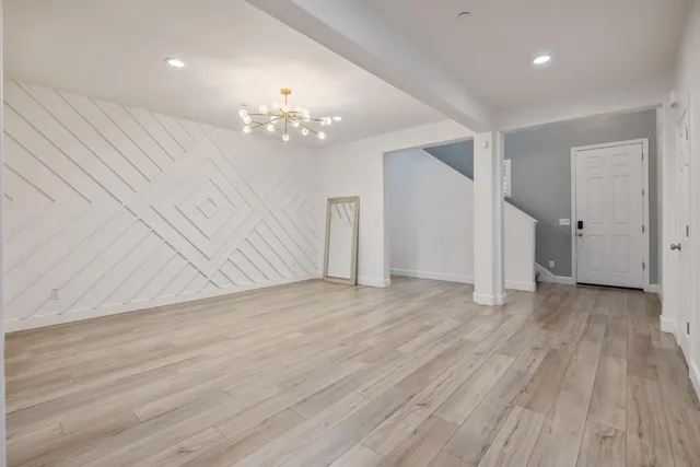 a view of kitchen with kitchen island a sink wooden floor and a counter top space