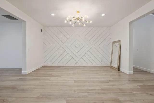 an empty room with wooden floor and a ceiling fan