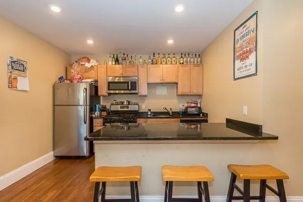 a kitchen with stainless steel appliances granite countertop a refrigerator and a stove top oven