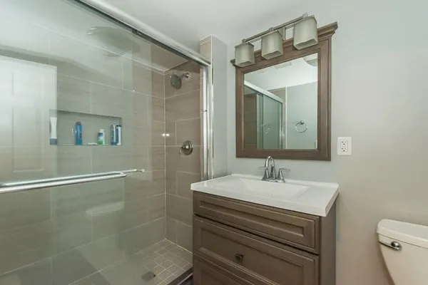 a bathroom with a sink mirror and a shower