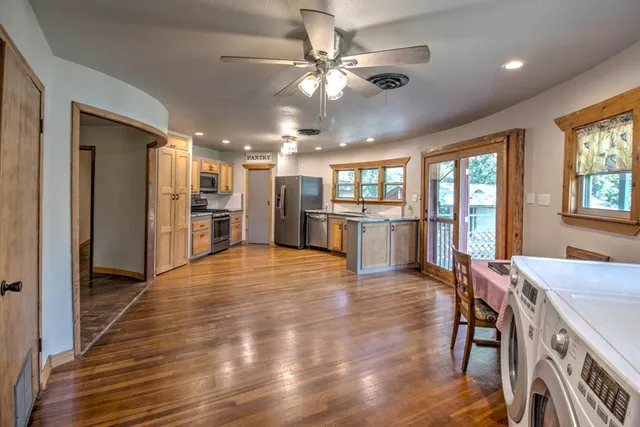 a view of kitchen with refrigerator stove and wooden floor