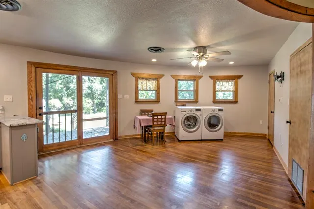 a view of a livingroom with furniture hardwood floor and windows