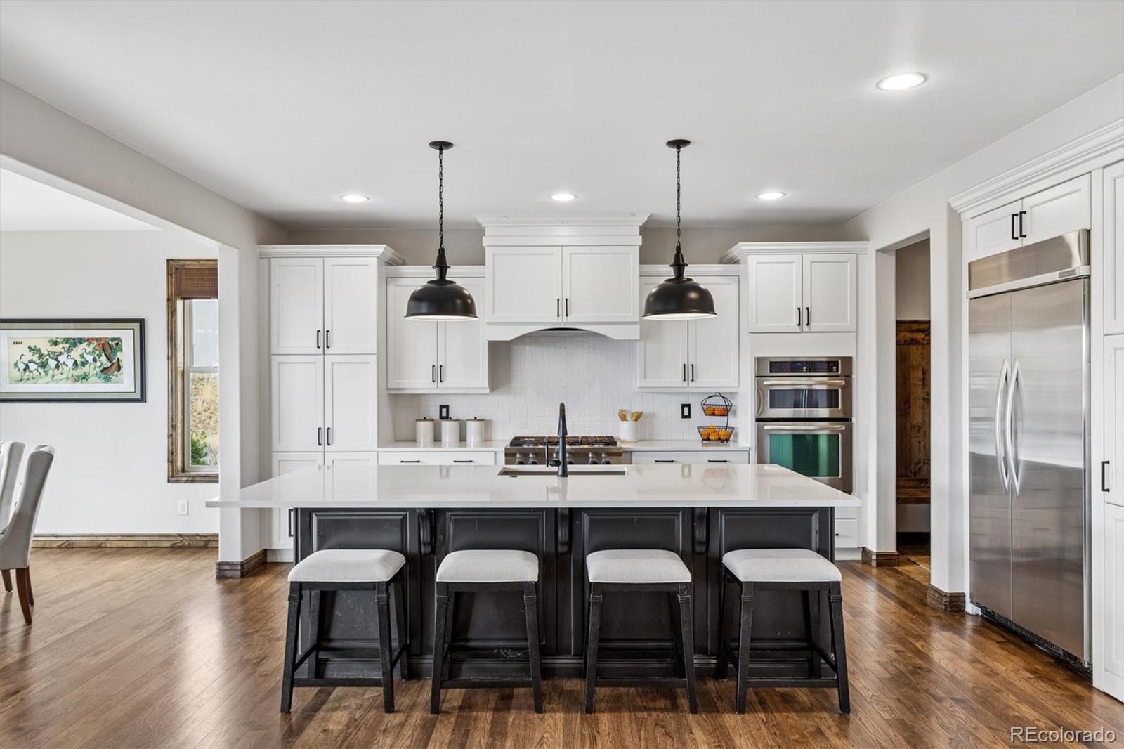 4698 Bandera Place Parker, CO 80134 - Photo 13 of 43 a kitchen with a dining table chairs stainless steel appliances and cabinets