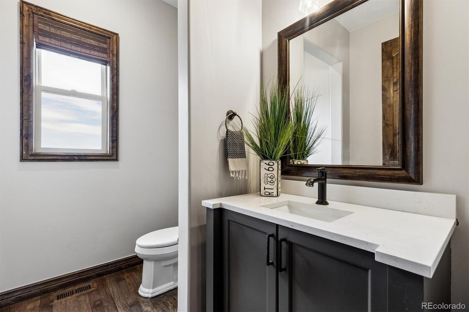 4698 Bandera Place Parker, CO 80134 - Photo 20 of 43 a bathroom with a sink a toilet and mirror