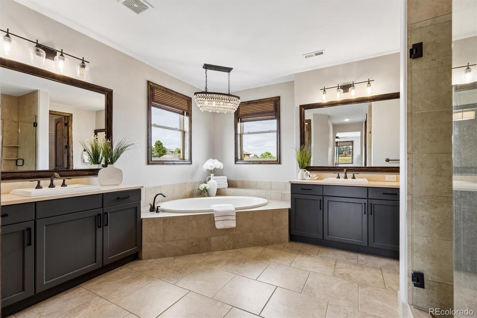 4698 Bandera Place Parker, CO 80134 - Photo 26 of 43 a spacious bathroom with a sink a vanity a mirror and bathtub