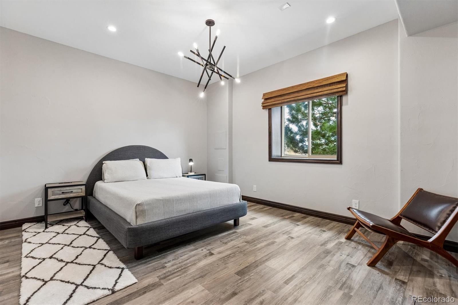 4698 Bandera Place Parker, CO 80134 - Photo 35 of 43 a bedroom with a bed and a chandelier