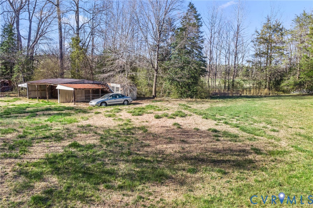 19161 Hollowing Creek Road Beaverdam, VA 23015 - Photo 12 of 27 a backyard of a house with large trees and outdoor seating