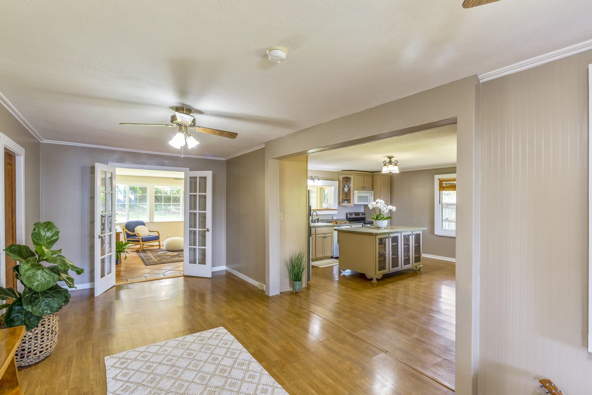 815 Kuulei Street Haiku, HI 96708 - Photo 3 of 25 a dining room with wooden floor and a chandelier