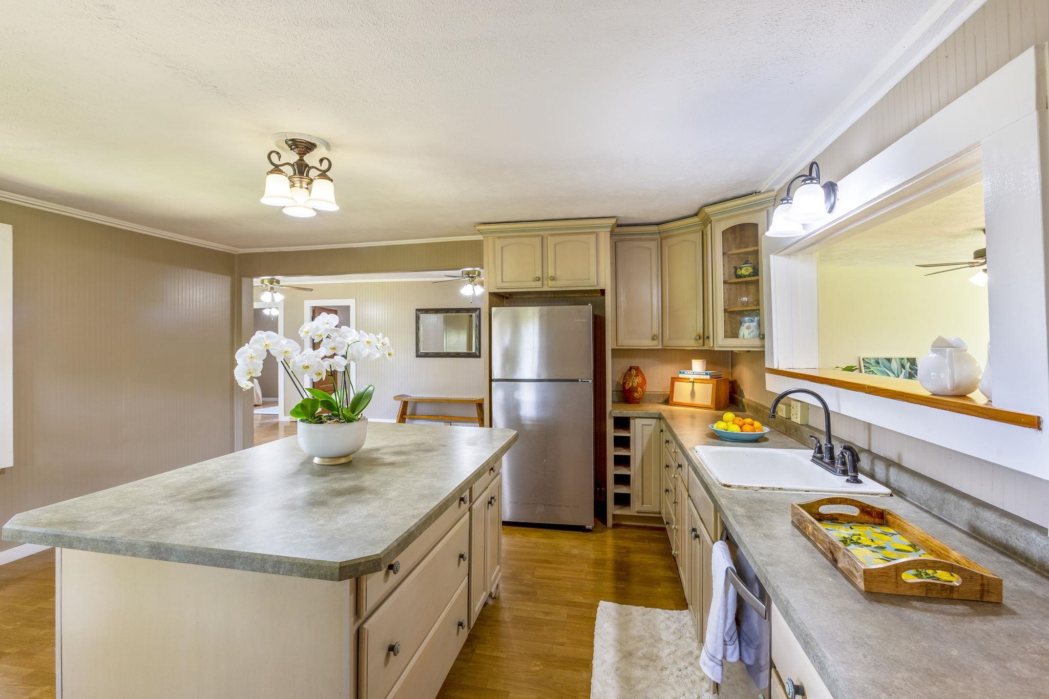 815 Kuulei Street Haiku, HI 96708 - Photo 6 of 25 a kitchen with stainless steel appliances granite countertop a sink dishwasher and a refrigerator with wooden floor