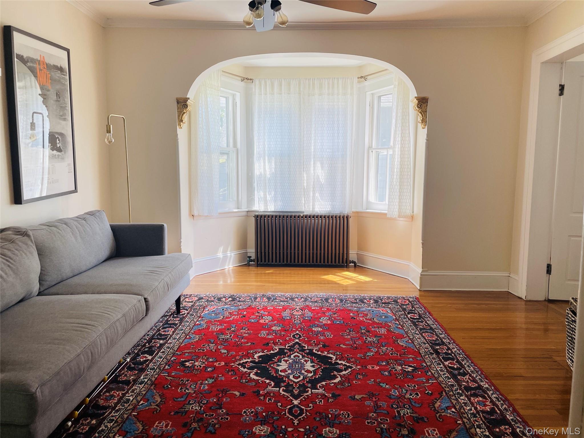 12 Parrott Street Cold Spring, NY 10516 - Photo 5 of 18 Living area featuring ornamental molding, wood floors, ceiling fan and arched walkways