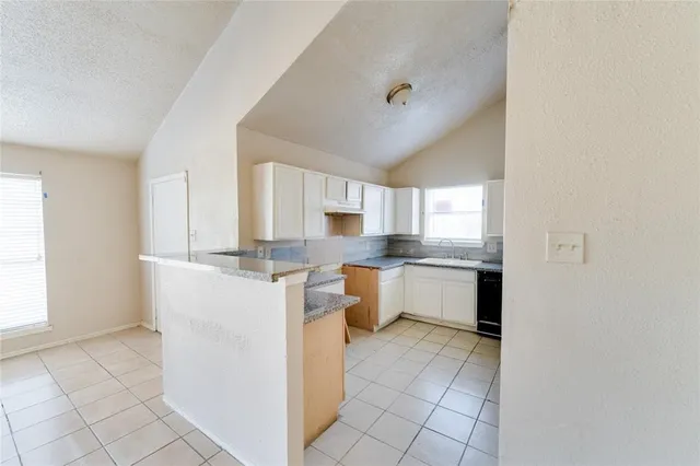 a kitchen with white cabinets and white appliances