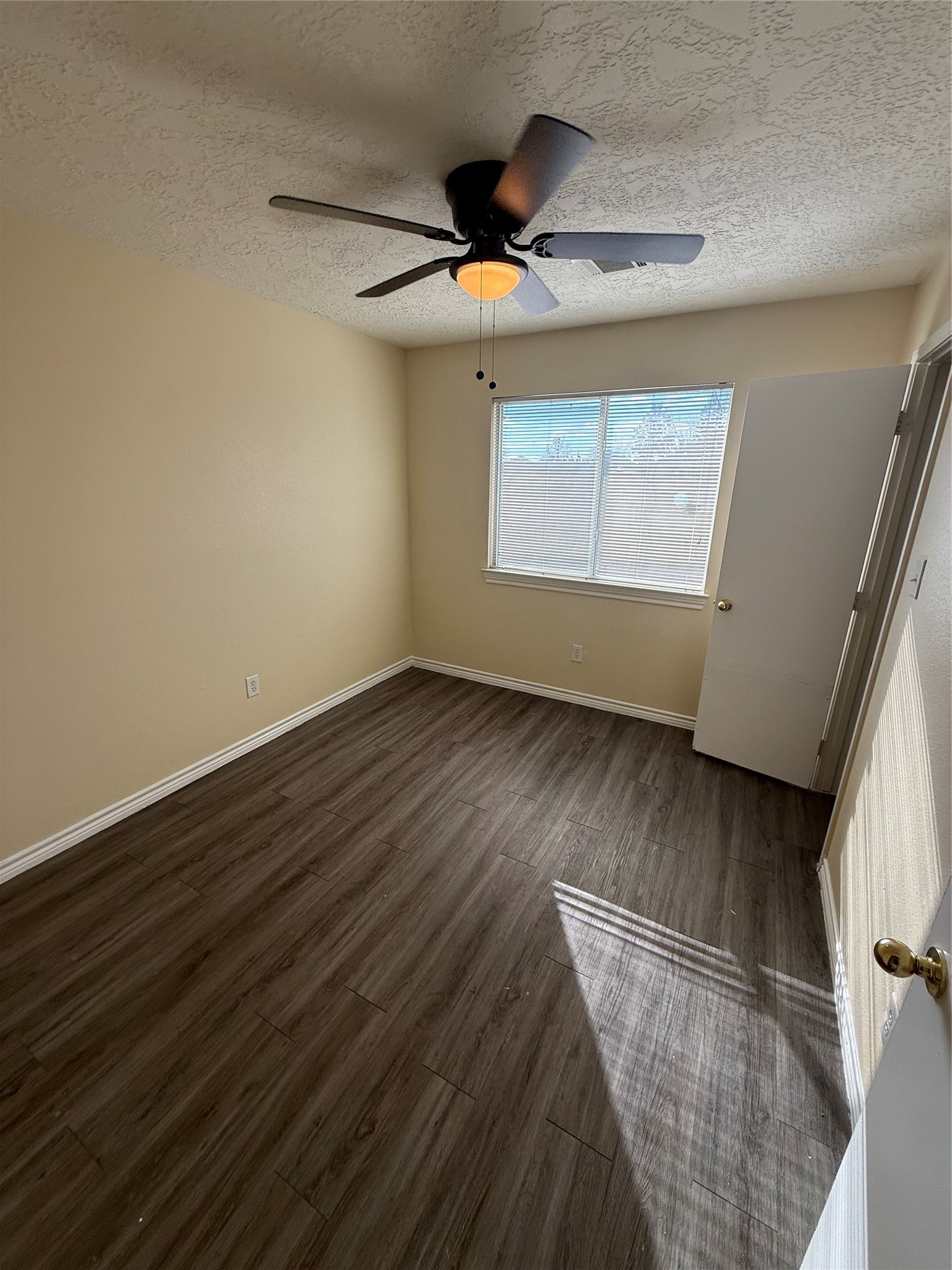 10918 Jutland Road Houston, TX 77048 - Photo 10 of 11 an empty room with wooden floor fan and windows