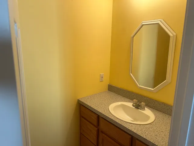 a bathroom with a granite countertop sink and a mirror