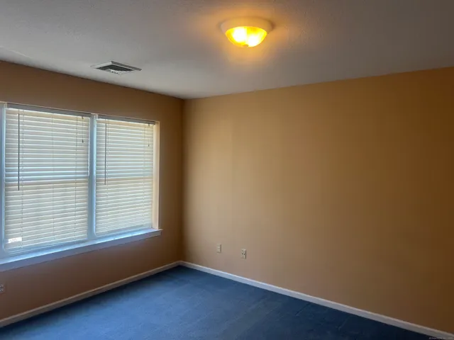an empty room with a window and wooden floor