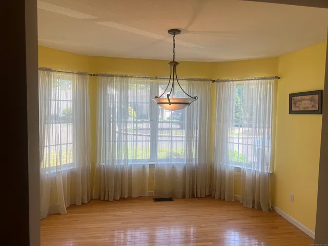 a view of a room with wooden floor windows and chandelier