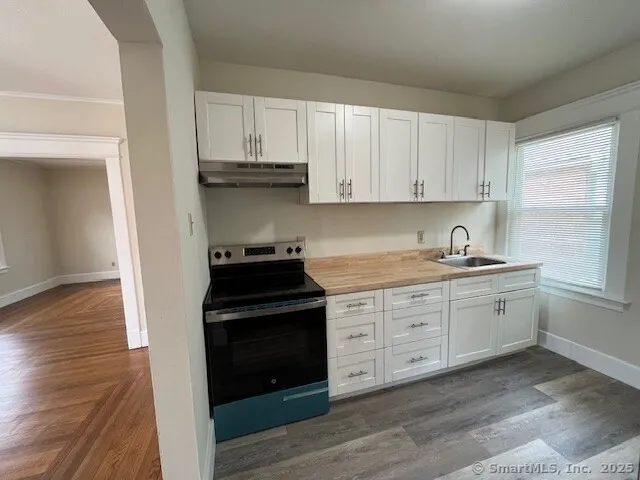 a kitchen with granite countertop white cabinets and black appliances