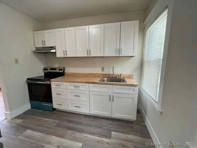 a kitchen with granite countertop white cabinets and white appliances