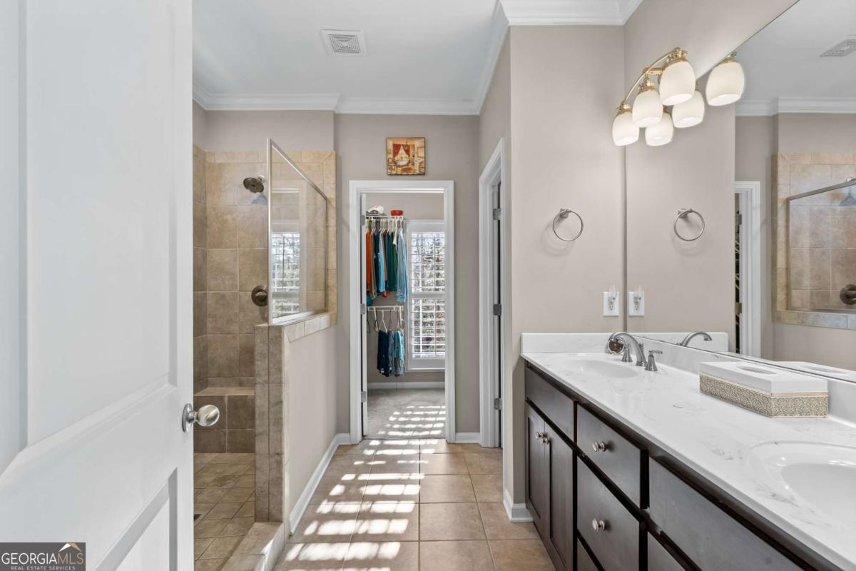 96 Morgan Trail, Unit 15R Ellijay, GA 30536 - Photo 33 of 42 a spacious bathroom with a granite countertop sink a mirror and shower