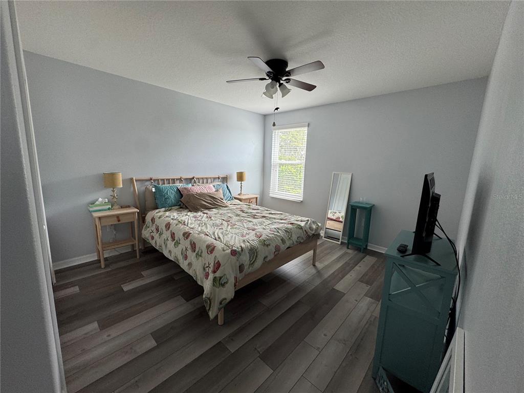 11832 Lake Boulevard New Port Richey, FL 34655 - Photo 34 of 58 a bedroom with a bed and wooden floor