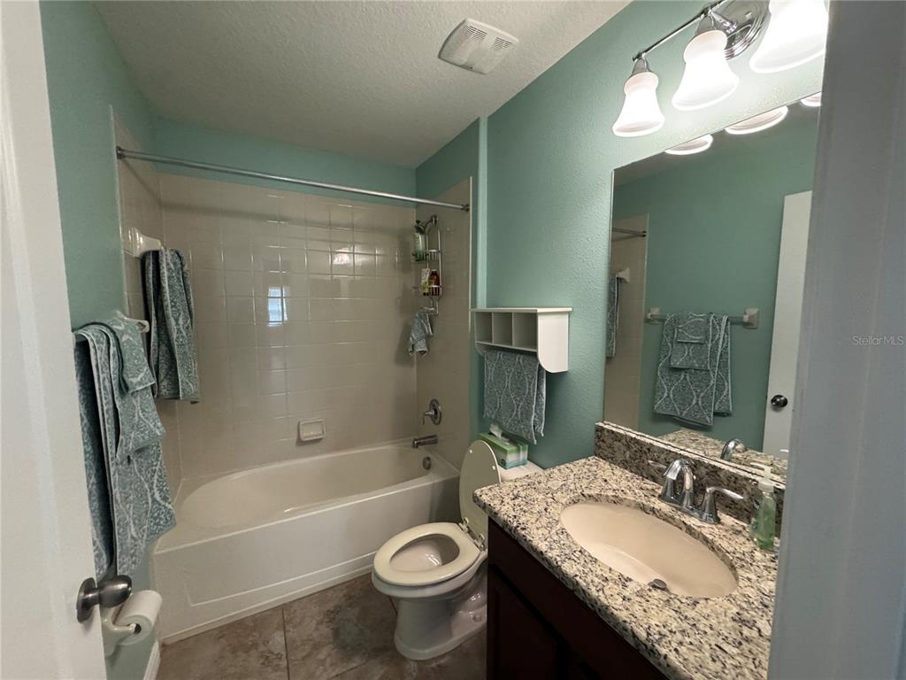 11832 Lake Boulevard New Port Richey, FL 34655 - Photo 45 of 58 a bathroom with a granite countertop sink toilet and shower