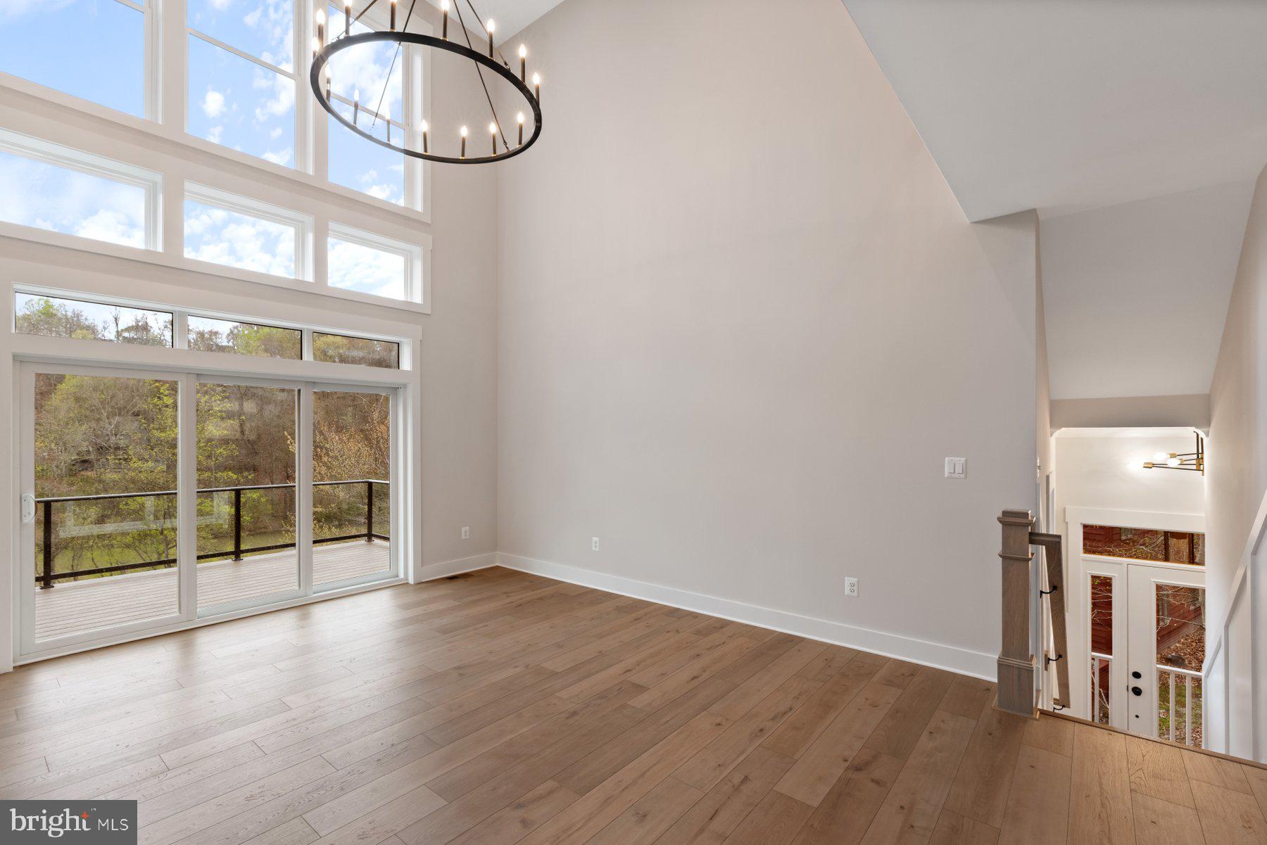 6719 West Lakeridge Road New Market, MD 21774 - Photo 13 of 49 an empty room with wooden floor and windows
