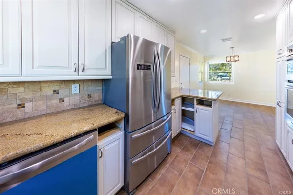 a kitchen with stainless steel appliances granite countertop a refrigerator and a sink