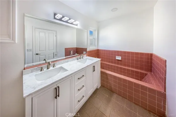 a bathroom with a double vanity sink a mirror and a