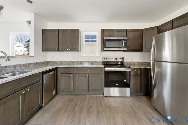 a kitchen with a sink a refrigerator and a stove top oven