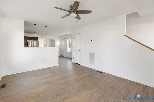 a view of a kitchen with wooden floor and a ceiling fan