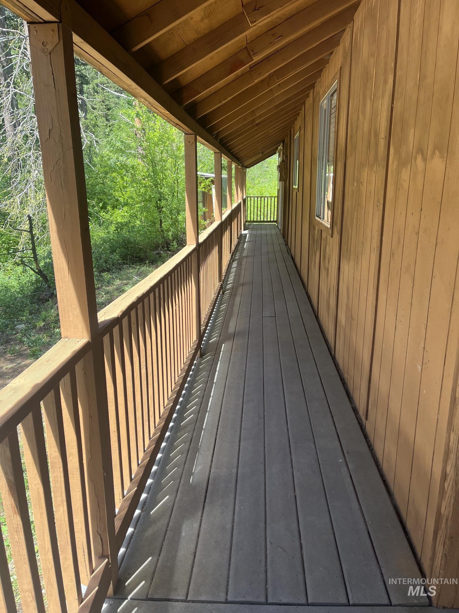 39 Mayflower Mine Road Placerville, ID 83666 - Photo 6 of 36 Covered wood-plank porch with wood railing and exposed rafter ceiling