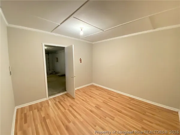 an empty room with wooden floor and bathroom