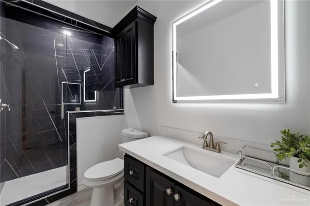 a bathroom with a granite countertop sink toilet and shower