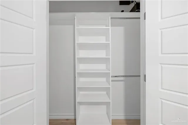 a view of walk in closet with empty racks