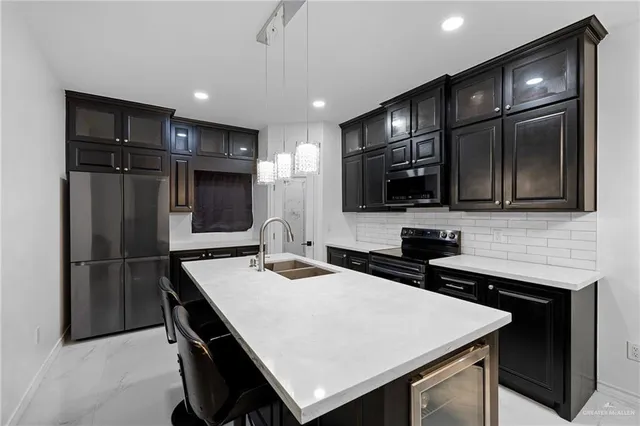a kitchen with kitchen island a sink appliances and cabinets