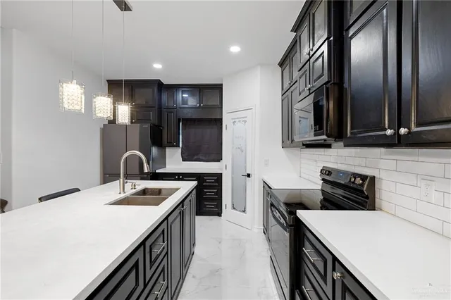 a kitchen that has a sink and a stove in it