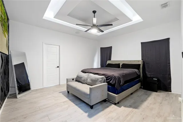a spacious bedroom with a bed and a flat screen tv
