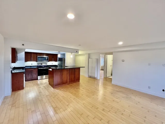 a large kitchen with stainless steel appliances wooden floors and center island