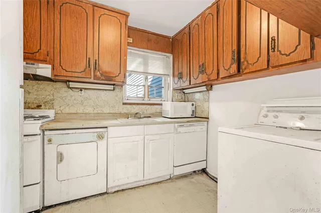 a kitchen with granite countertop white cabinets and white appliances